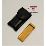 A Cartier of Paris textured gold plated and enamelled pocket cigarette lighter, No.C32986, in