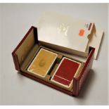 Two sealed packs of Le Must de Cartier playing cards in fitted red Moroccan leather case and card