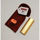 A Cartier textured gold plated cased pocket cigarette lighter No. C85764 in red suede pouch