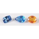 Three loose synthetic stones, being blue sapphire, orange sapphire, and a tanzanite, each with