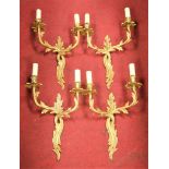 A set of four Rococo style gilt metal twin sconce wall light fittings, height 53cm (including