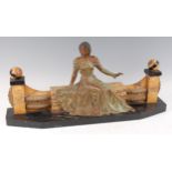 An Art Deco spelter and marble sculpture, of a lady in seated pose, wearing long flowing dress,