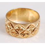 An 18ct yellow gold wedding band, with a diamond cut pattern, width 10mm, size O, gross weight 7.3g,