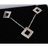 A pair of 18ct white gold diamond earrings together with a matching pendant, the open square