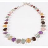 A contemporary silver multi-stone set necklet, arranged as graduated and alternating rough cut