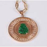 A yellow metal circular jadeite pendant, the openwork pendant featuring a carved jadeite Buddha to
