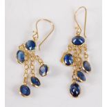 A pair of yellow metal and blue sapphire ear pendants, on shepherds crook fittings, having a