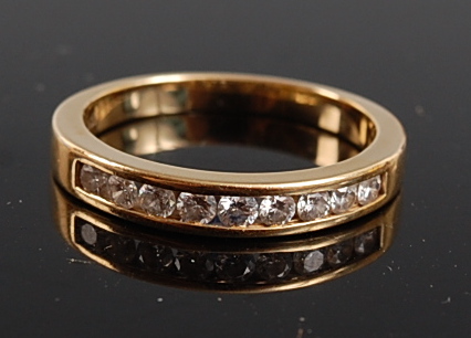 A yellow metal diamond half hoop eternity ring , the 9 round brilliant cut diamonds in a channel