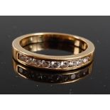 A yellow metal diamond half hoop eternity ring , the 9 round brilliant cut diamonds in a channel