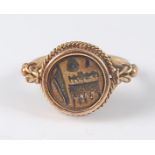 A yellow metal circular signet ring, the ring having a centre intaglio carving of an indistinct