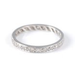 A white metal diamond eternity ring, comprising 24 round brilliant cut diamonds in millegrain