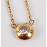 A contemporary 18ct gold diamond pendant, the brilliant cut diamond in a rubover setting, weighing