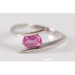 A contemporary 18ct white gold and pink sapphire set dress ring, the oval cut sapphire weighing