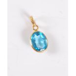 A topaz pendant, the oval faceted topaz, approx. 7.9 x 9.9 x 4.6mm, spectacle set in unmarked yellow