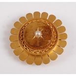A yellow metal circular brooch of sunflower design , the centre raised panel with a 3.3mm seed pearl