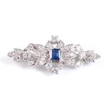 A white metal Art Deco style lozenge shaped brooch, featuring a centre square cut sapphire within