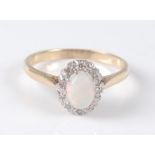 An 18ct yellow and white gold, opal and diamond oval cluster ring, the centre white opal cabochon