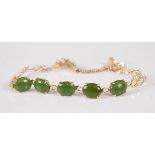 A yellow metal and jade set bracelet, arranged as five four-claw set cabochon jades on stylised