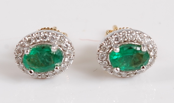 A pair of 18ct yellow and white gold oval emerald and diamond cluster earrings, in claw settings,