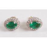 A pair of 18ct yellow and white gold oval emerald and diamond cluster earrings, in claw settings,