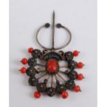 A fan shaped coral stick pin, with eleven filigree style spokes with 4mm coral bead terminals (two