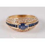 An 18ct yellow gold, sapphire and diamond dress ring, featuring a centre oval faceted sapphire in