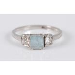 A stamped platinum, aquamarine and diamond three-stone ring, the ring comprising a step cut