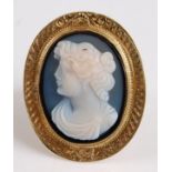 A yellow metal oval hardstone cameo ring, featuring a Roman lady in profile within a heavy