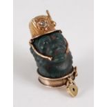 A Victorian bloodstone and yellow metal grotesque pendant / charm, modelled as a monkey head wearing