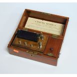 A circa 1900 mahogany cased electric current machine, by the Army & Navy Co-Operative Society,