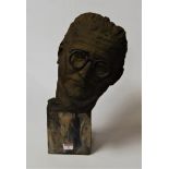 A composition bust of a male wearing glasses, raised on a composition and polished hardstone base,