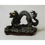 A Chinese glazed stoneware figure of a four clawed dragon, raised on stained wooden plinth, height