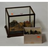 A collection of plastic military figures, mounted in a desert setting, within glazed display case;