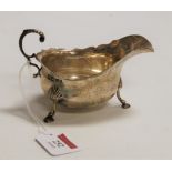 An Edwardian silver sauceboat, of plain undecorated form, having flying C-scroll handle and on