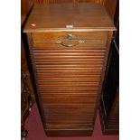 An early 20th century walnut single tambour fronted office filing cabinet, having panelled sides,