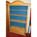 A contemporary pine arch topped freestanding open bookshelf, having single long lower drawer, w.