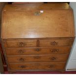 An early 19th century provincial oak slopefront writing bureau, having two short over three long