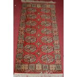 A Persian style red ground Bokhara hall rug, 144 x 69cm