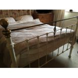 A Victorian style cream painted tubular metal and brass kingsize bedstead, having side rails,