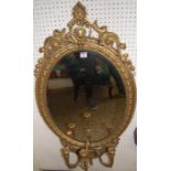 A 19th century giltwood floral decorated oval wall mirror, having three branch lower candle