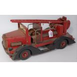 A large scale home made model of a wooden and tinplate fire engine comprising of red body with black