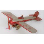 A Wells or Chad Valley tin plate and clockwork model of a single seater aircraft comprising silver