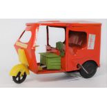 An unusual tin plate and plastic clockwork model of a Tuk-tuk, finished in orange and yellow with