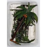 A small tray containing a quantity of various Britains palm and exotic trees, all with minor