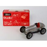 A Schuco No. 1050 Studio Racing Car comprising of silver body with red interior and detailed tin