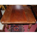 An Edwardian walnut extending dining table, having a wind-out action and single drop-in leaf, max