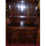 A 17th century style joined and moulded oak dresser, having two-tier open plate rack over base