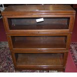 A 1930s oak three-tier stacking bookcase, having typical glazed hinged doors, width 91cm