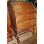 A 1920s moulded oak slopefront two drawer writing bureau, width 64cm; together with a 1920s barley