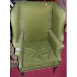 A 19th century mahogany framed and green upholstered deep wing-backed armchair, raised on ring